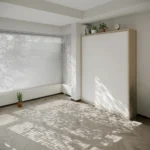 Space-efficient wall bed with foldable desk and built-in storage.